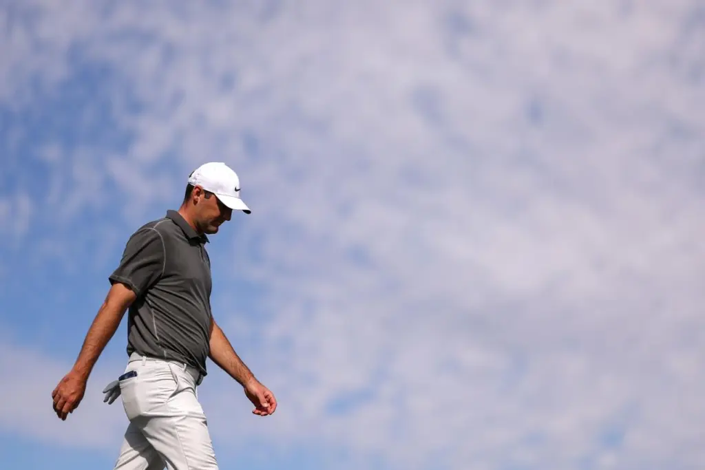 Scottie Scheffler walks calmly across the golf course after intense media attention.